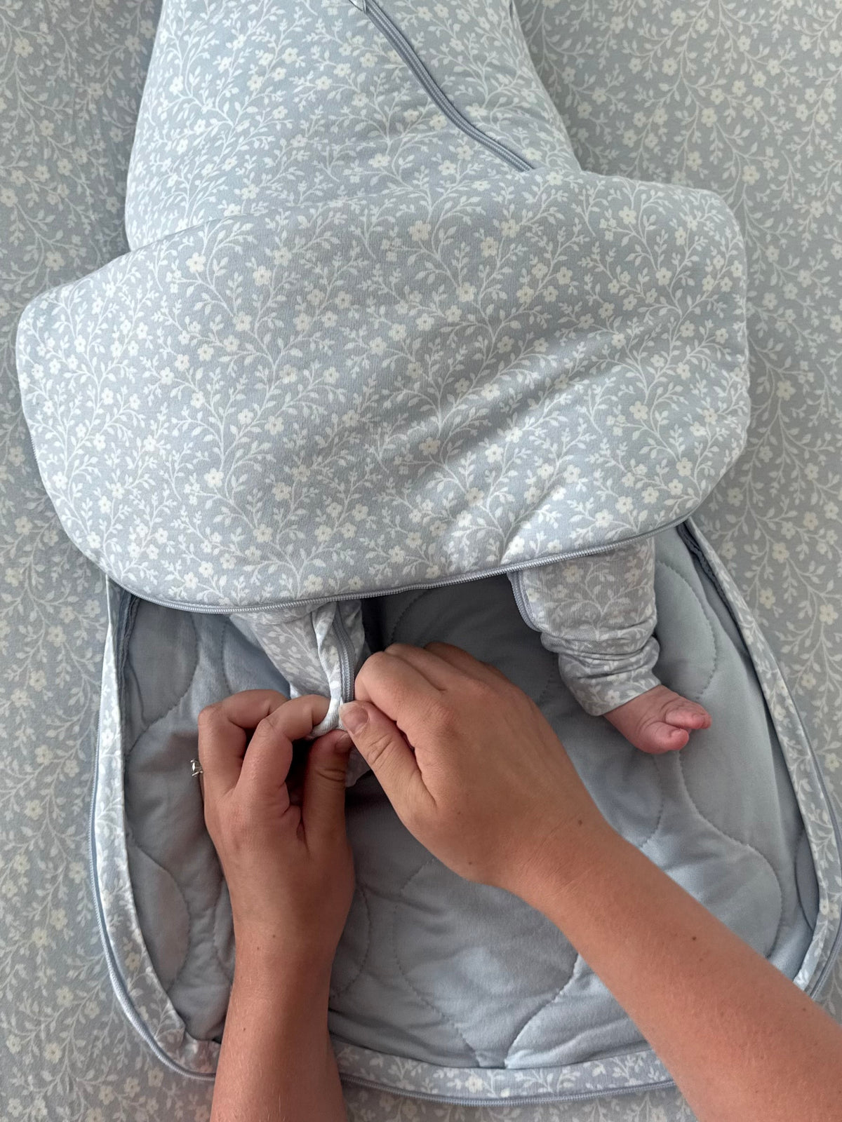 Light blue floral 1.0 TOG swaddle sleep sack with zipper and adjustable closures